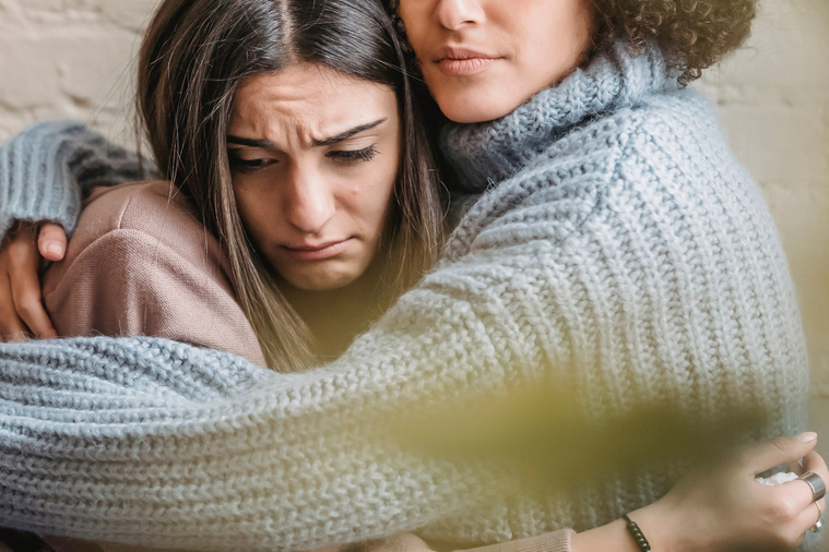 Crop woman hugging sad girlfriend